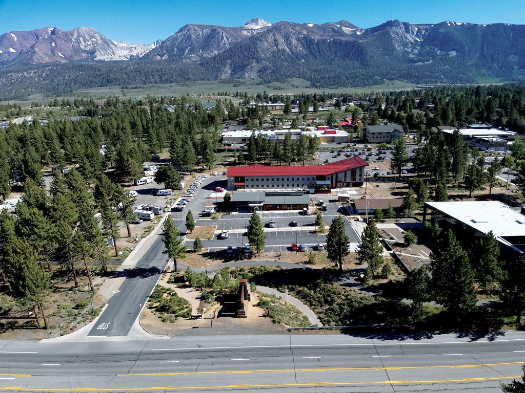 An aerial shot above the Town of Mammoth Lakes with buildings and mountains